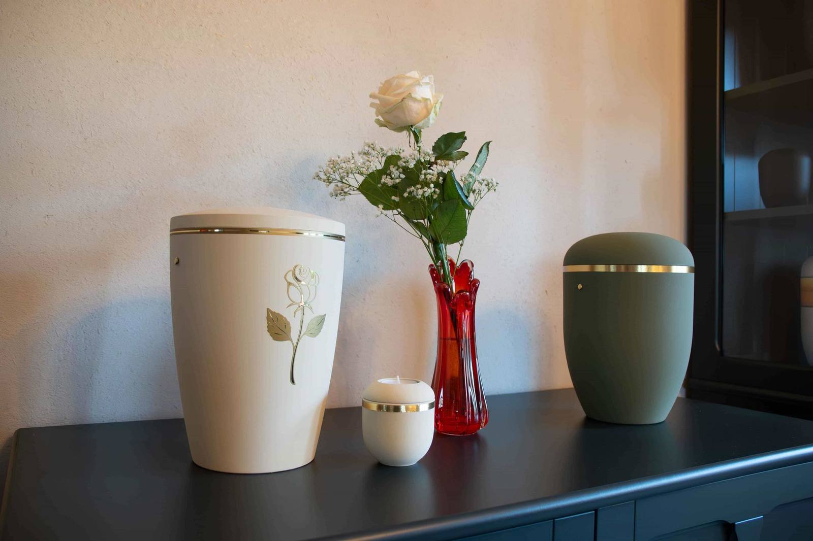 Urnen-Ausstellung mit Rose im Bestattungshaus Focke
